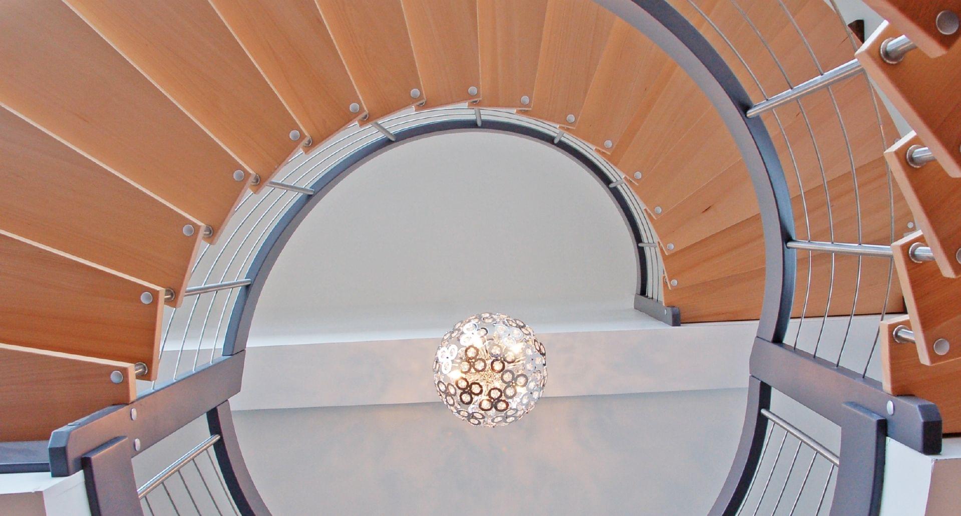 Escalier courbe suspendu type Nova. Marche en bois de hêtre naturel et rampe laqué. Balustres et reling en inox.
