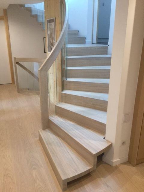 Escalier Epura Linéa courbe. Marches et contremarches en chêne massif. Rampe débillardé avec verre stadip.