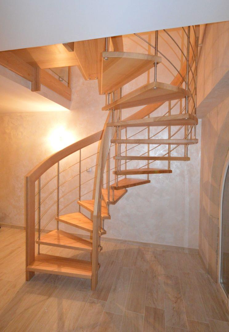 Escalier suspendu courbe. Main-courantes débillardées en bois laméllé-collé. Marches en frêne massif. Remplisage des rampes par balustres bois et lisses inox.