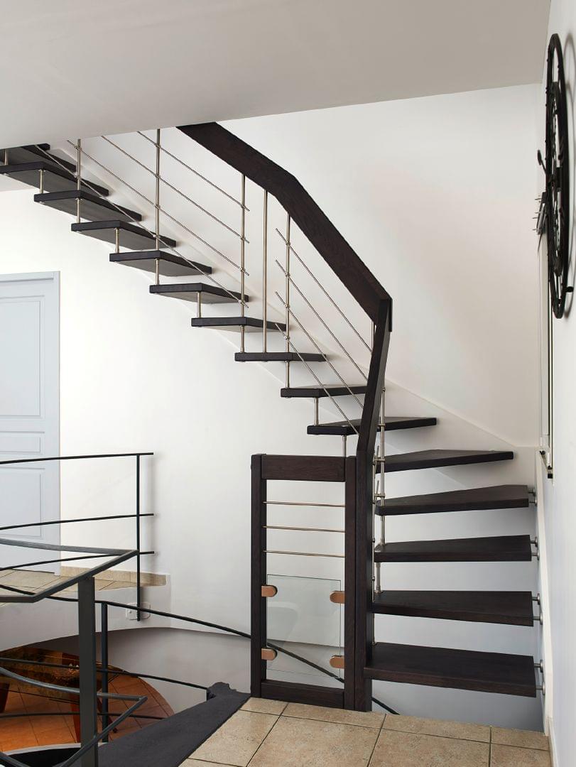 Escalier suspendu teinté noir, garde-corps en inox